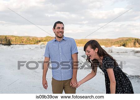 Stock Photo - Couple laughing on snow-covered landscape, Ottawa, Ontario. Fotosearch