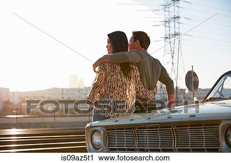 Couple leaning against car bonnet looking away, Los Angeles, California, USA View Large Photo Image Stock Image - Couple leaning against car bonnet looking away, Los Angeles, California, USA. Fotosearch