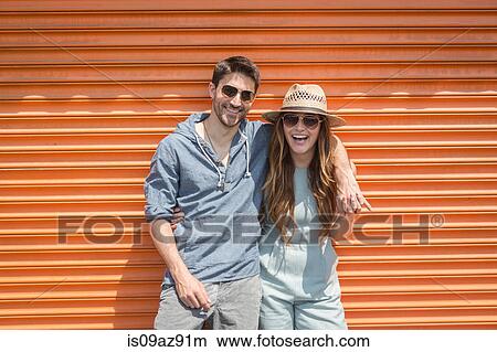 Couple leaning against orange shutters looking at camera, Coney island, Brooklyn, New York, USA View Large Photo Image Picture - Couple leaning against orange shutters looking at camera, Coney island, Brooklyn, New York, USA. Fotosearch