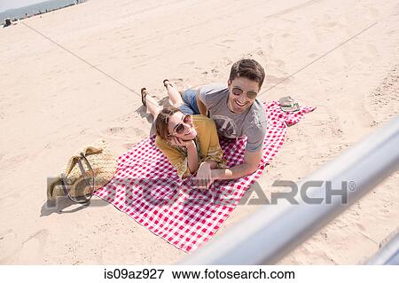 Couple lying on picnic blanket on beach, Coney island, Brooklyn, New York, USA View Large Photo Image Stock Photo - Couple lying on picnic blanket on beach, Coney island, Brooklyn, New York, USA. Fotosearch