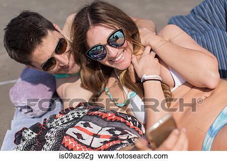 Couple on beach taking selfie smiling, Coney island, Brooklyn, New York, USA View Large Photo Image Stock Image - Couple on beach taking selfie smiling, Coney island, Brooklyn, New York, USA. Fotosearch