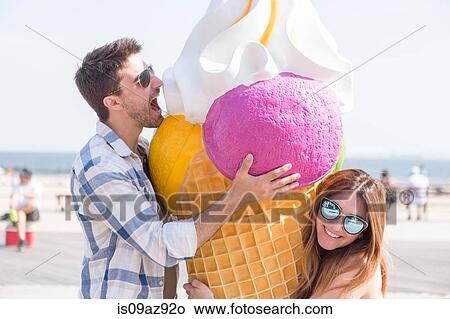 Couple on beach with giant ice cream cone, Coney island, Brooklyn, New York, USA View Large Photo Image Picture - Couple on beach with giant ice cream cone, Coney island, Brooklyn, New York, USA. Fotosearch