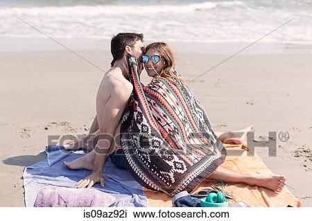 Couple on beach wrapped in blanket, Coney island, Brooklyn, New York, USA View Large Photo Image Stock Image - Couple on beach wrapped in blanket, Coney island, Brooklyn, New York, USA. Fotosearch