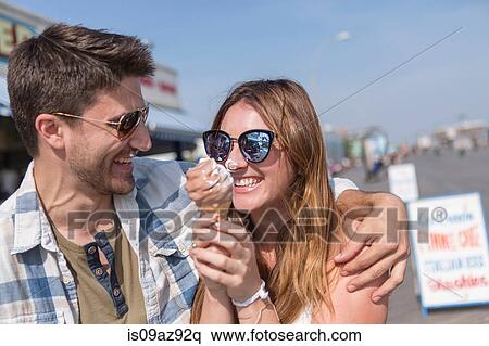 Couple on promenade holding ice cream cones smiling, Coney island, Brooklyn, New York, USA View Large Photo Image Stock Photography - Couple on promenade holding ice cream cones smiling, Coney island, Brooklyn, New York, USA. Fotosearch