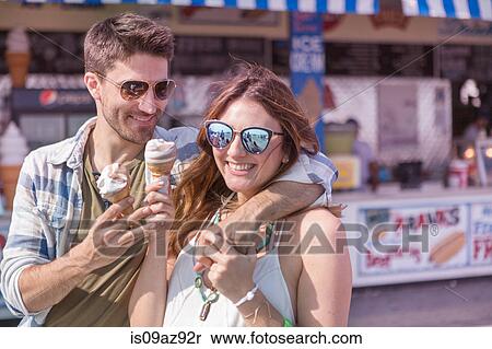 Couple on promenade holding ice cream cones smiling, Coney island, Brooklyn, New York, USA View Large Photo Image Stock Photography - Couple on promenade holding ice cream cones smiling, Coney island, Brooklyn, New York, USA. Fotosearch