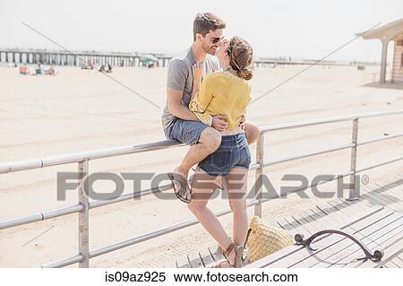Couple on railings by beach kissing, Coney island, Brooklyn, New York, USA View Large Photo Image Stock Photography - Couple on railings by beach kissing, Coney island, Brooklyn, New York, USA. Fotosearch