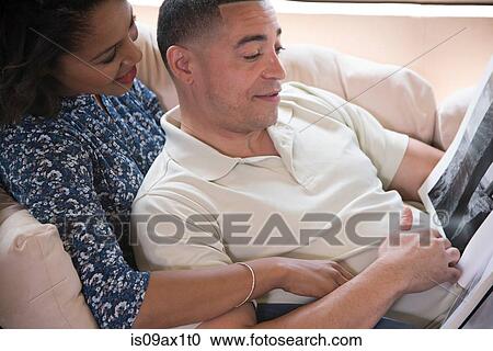 Couple reading book on sofa View Large Photo Image Stock Image - Couple reading book on sofa. Fotosearch