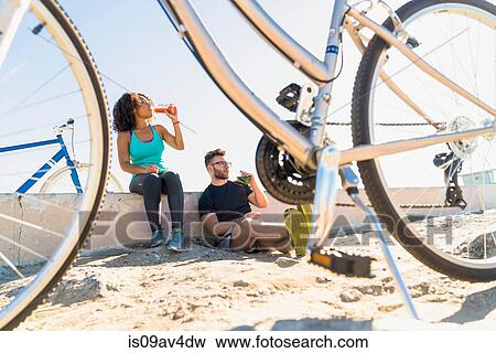 Couple relaxing after bike ride, bicycles beside them View Large Photo Image Stock Photo - Couple relaxing after bike ride, bicycles beside them. Fotosearch