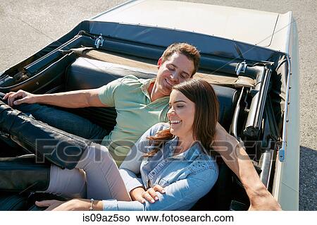 Couple relaxing in convertible car, Los Angeles, California, USA View Large Photo Image Picture - Couple relaxing in convertible car, Los Angeles, California, USA. Fotosearch