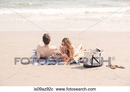 Stock Image - Couple relaxing on beach, Coney island, Brooklyn, New York, USA. Fotosearch