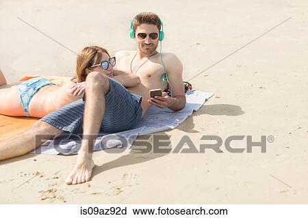 Stock Image - Couple relaxing on beach, Coney island, Brooklyn, New York, USA. Fotosearch