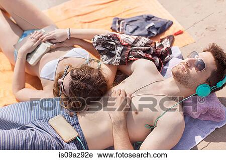 Couple relaxing on beach, Coney island, Brooklyn, New York, USA View Large Photo Image Stock Image - Couple relaxing on beach, Coney island, Brooklyn, New York, USA. Fotosearch