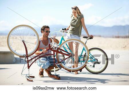 Couple repairing bicycle at Venice Beach, Los Angeles, California, USA View Large Photo Image Stock Photo - Couple repairing bicycle at Venice Beach, Los Angeles, California, USA. Fotosearch