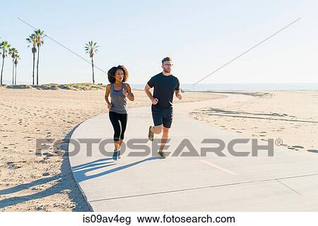 Couple running on pathway at beach View Large Photo Image Stock Image - Couple running on pathway at beach. Fotosearch
