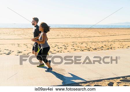 Couple running on pathway at beach View Large Photo Image Stock Image - Couple running on pathway at beach. Fotosearch