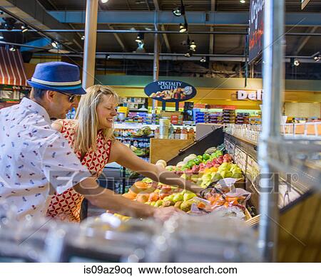 Stock Photography - Couple shopping for fruit and vegetables in supermarket. Fotosearch