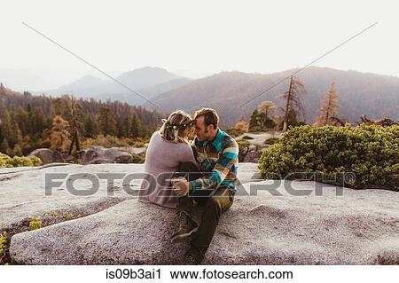 Stock Image - Couple sitting on rocks in mountains, Sequoia national park, California, USA. Fotosearch