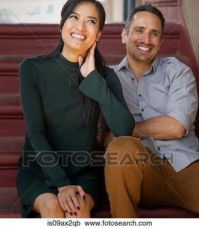 Couple sitting on stairway looking away smiling View Large Photo Image Stock Image - Couple sitting on stairway looking away smiling. Fotosearch