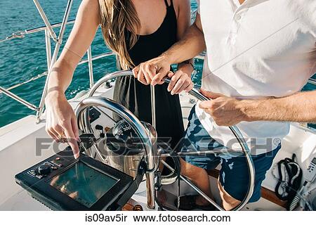 Stock Photography - Couple steering wheel of sailboat. Fotosearch