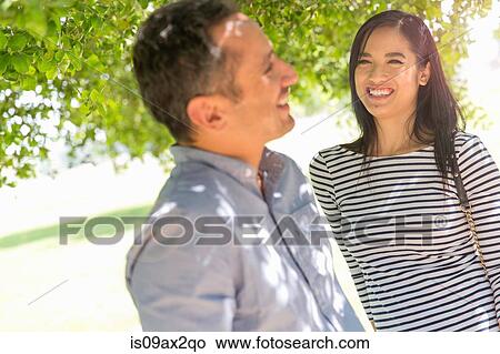 Couple underneath tree face to face smiling View Large Photo Image Picture - Couple underneath tree face to face smiling. Fotosearch