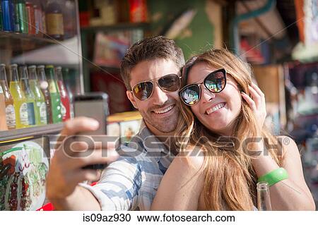 Couple using smartphone to take selfie, Coney island, Brooklyn, New York, USA View Large Photo Image Stock Image - Couple using smartphone to take selfie, Coney island, Brooklyn, New York, USA. Fotosearch