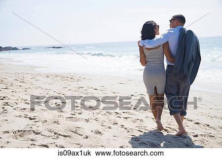 Couple walking and enjoying beach View Large Photo Image Stock Image - Couple walking and enjoying beach. Fotosearch