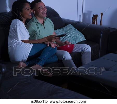 Couple watching television with popcorn on sofa View Large Photo Image Stock Image - Couple watching television with popcorn on sofa. Fotosearch
