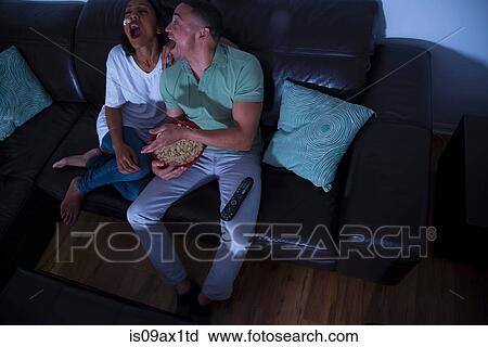 Couple watching television with popcorn on sofa View Large Photo Image Stock Image - Couple watching television with popcorn on sofa. Fotosearch