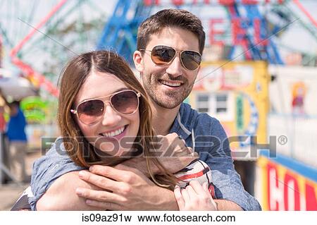 Couple wearing sunglasses looking at camera smiling, Coney island, Brooklyn, New York, USA View Large Photo Image Stock Photo - Couple wearing sunglasses looking at camera smiling, Coney island, Brooklyn, New York, USA. Fotosearch