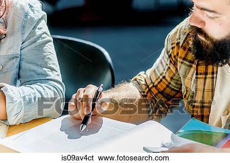 Cropped shot of male and female college students reading at desk View Large Photo Image Stock Photograph - Cropped shot of male and female college students reading at desk. Fotosearch
