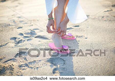 Picture - Cropped shot of woman fastening anklet on Santa Monica beach, Cresent City, California, USA. Fotosearch