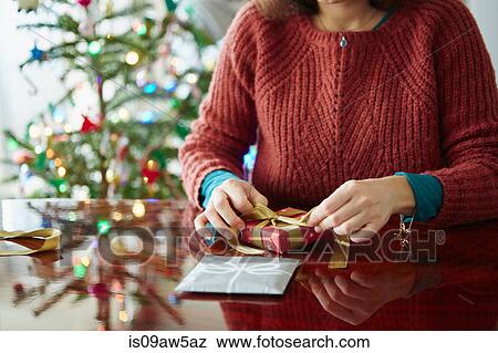 Cropped shot of woman wrapping xmas gift at table View Large Photo Image Stock Photo - Cropped shot of woman wrapping xmas gift at table. Fotosearch