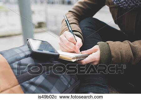 Cropped shot of woman writing in notebook in city View Large Photo Image Stock Image - Cropped shot of woman writing in notebook in city. Fotosearch