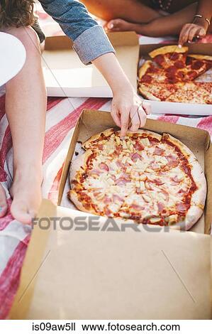 Cropped view of friends sharing a pizza View Large Photo Image Stock Image - Cropped view of friends sharing a pizza. Fotosearch