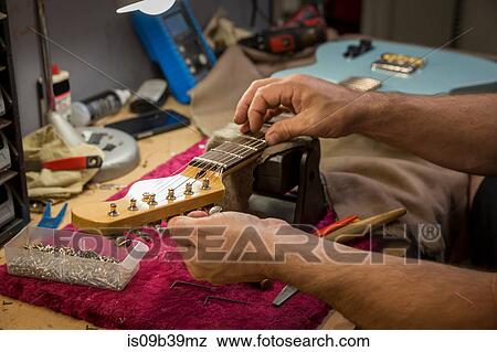 Cropped view of guitar maker's hands manufacturing guitar View Large Photo Image Stock Photo - Cropped view of guitar maker's hands manufacturing guitar. Fotosearch