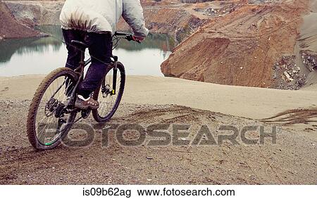 Cropped view of male mountain biker mountain biking down quarry hill View Large Photo Image Stock Image - Cropped view of male mountain biker mountain biking down quarry hill. Fotosearch