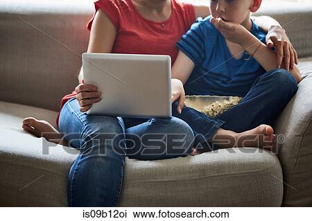 Cropped view of mother and son on sofa with popcorn using smartphone View Large Photo Image Stock Image - Cropped view of mother and son on sofa with popcorn using smartphone. Fotosearch