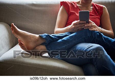 Cropped view of mother and son relaxing on sofa using smartphone View Large Photo Image Stock Image - Cropped view of mother and son relaxing on sofa using smartphone. Fotosearch