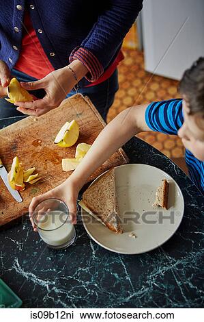 Cropped view of woman chopping apple for son's lunch View Large Photo Image Stock Image - Cropped view of woman chopping apple for son's lunch. Fotosearch