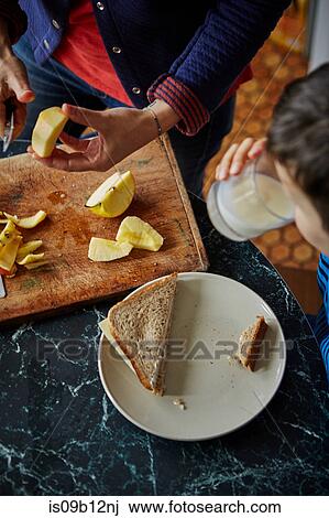 Cropped view of woman chopping apple for son's lunch View Large Photo Image Stock Image - Cropped view of woman chopping apple for son's lunch. Fotosearch