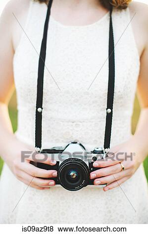 Cropped view of woman holding camera View Large Photo Image Stock Photo - Cropped view of woman holding camera. Fotosearch