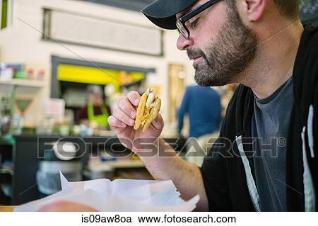 Customer enjoying sandwich in general store View Large Photo Image Stock Image - Customer enjoying sandwich in general store. Fotosearch