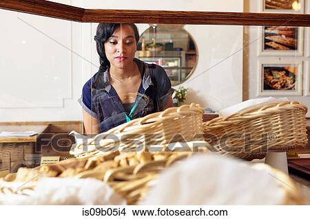 Picture - Customer in bakery looking at baked goods. Fotosearch