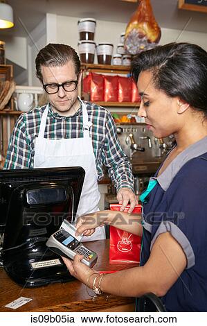 Customer in bakery paying for goods, using card machine, mid section View Large Photo Image Stock Image - Customer in bakery paying for goods, using card machine, mid section. Fotosearch