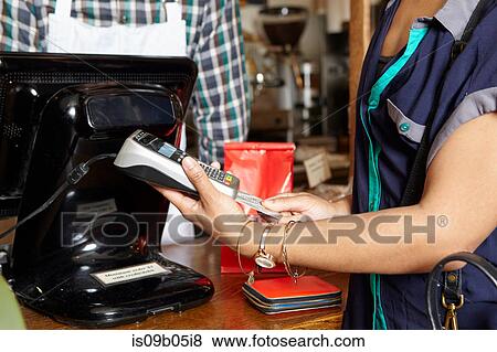 Customer in bakery paying for goods, using card machine, mid section View Large Photo Image Stock Photo - Customer in bakery paying for goods, using card machine, mid section. Fotosearch