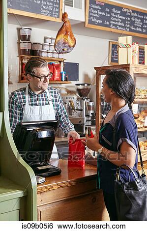 Stock Photograph - Customer in bakery paying for goods. Fotosearch