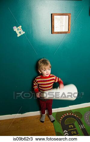 Cute male toddler rolling paper in playroom View Large Photo Image Stock Image - Cute male toddler rolling paper in playroom. Fotosearch