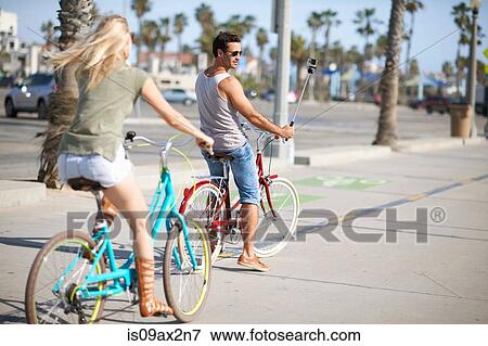 Stock Photo - Cycling couple cycling at Venice Beach, Los Angeles, California, USA. Fotosearch