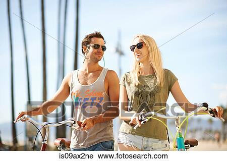 Cycling couple strolling at Venice Beach, Los Angeles, California, USA View Large Photo Image Stock Image - Cycling couple strolling at Venice Beach, Los Angeles, California, USA. Fotosearch