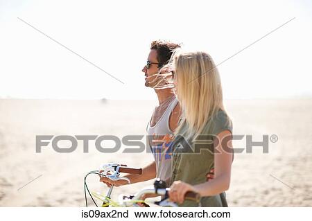 Cycling couple strolling with cycles on Venice Beach, Los Angeles, California, USA View Large Photo Image Stock Image - Cycling couple strolling with cycles on Venice Beach, Los Angeles, California, USA. Fotosearch